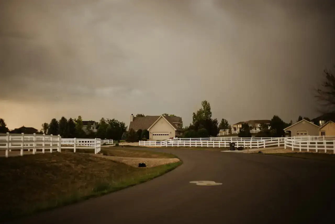 Suburban Colorado street with homes and white fences