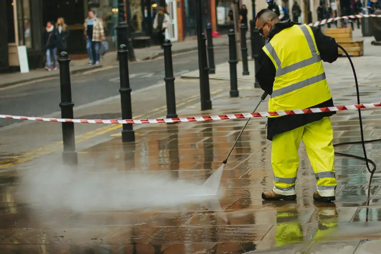 Worker spraying high-pressure water from a jetting wand